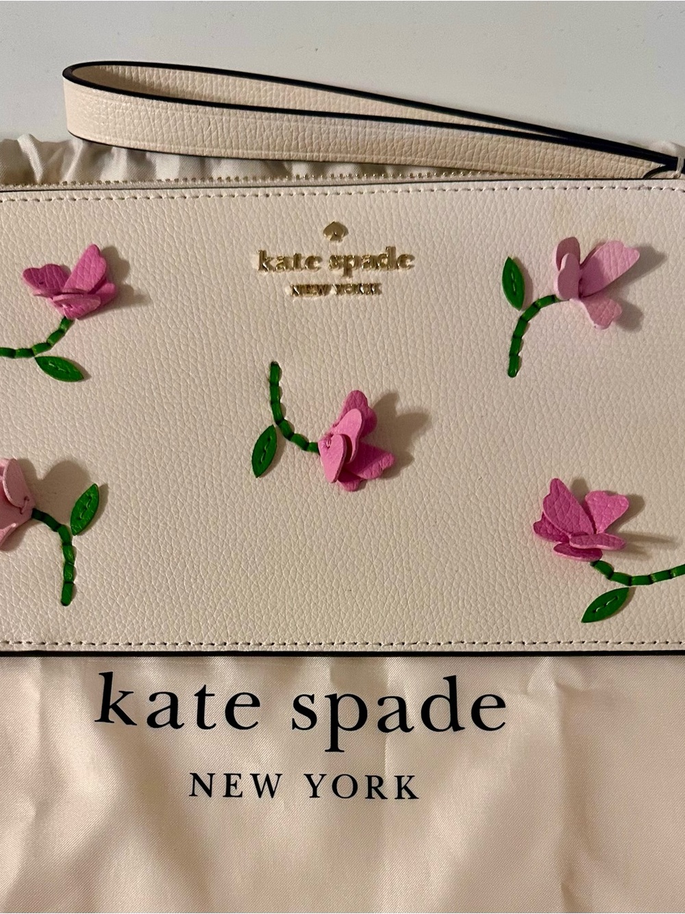 Kate Spade white wristlet with lilac floral appliqués and green leaves